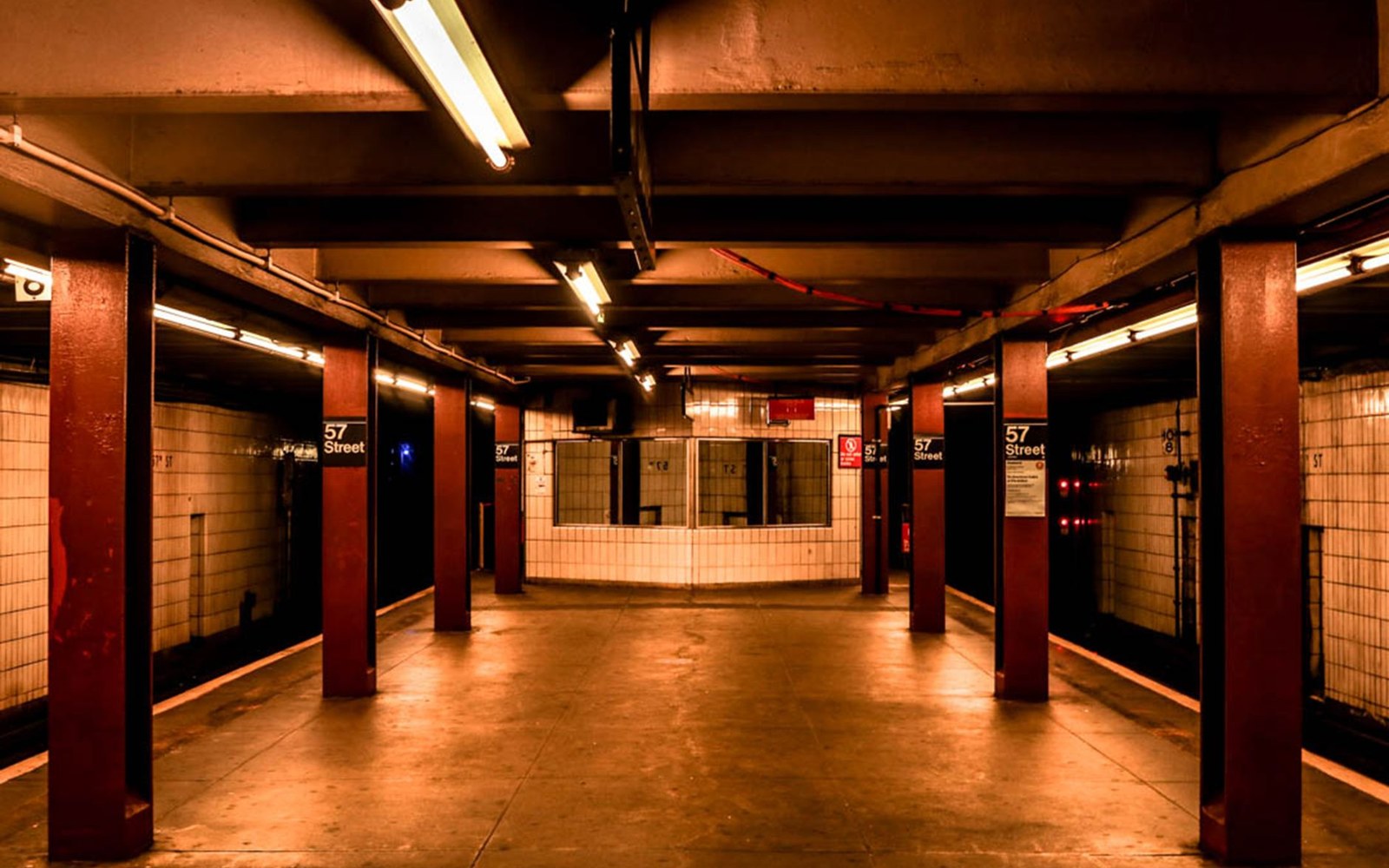 Empty 57th Street subway platform lined with dark red columns and tiled walls