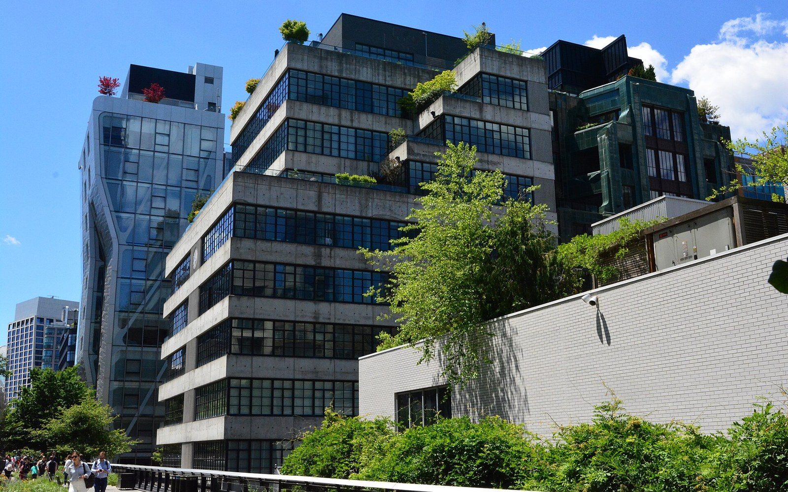 Rooftop terraces and greenery atop a concrete apartment building above the High Line