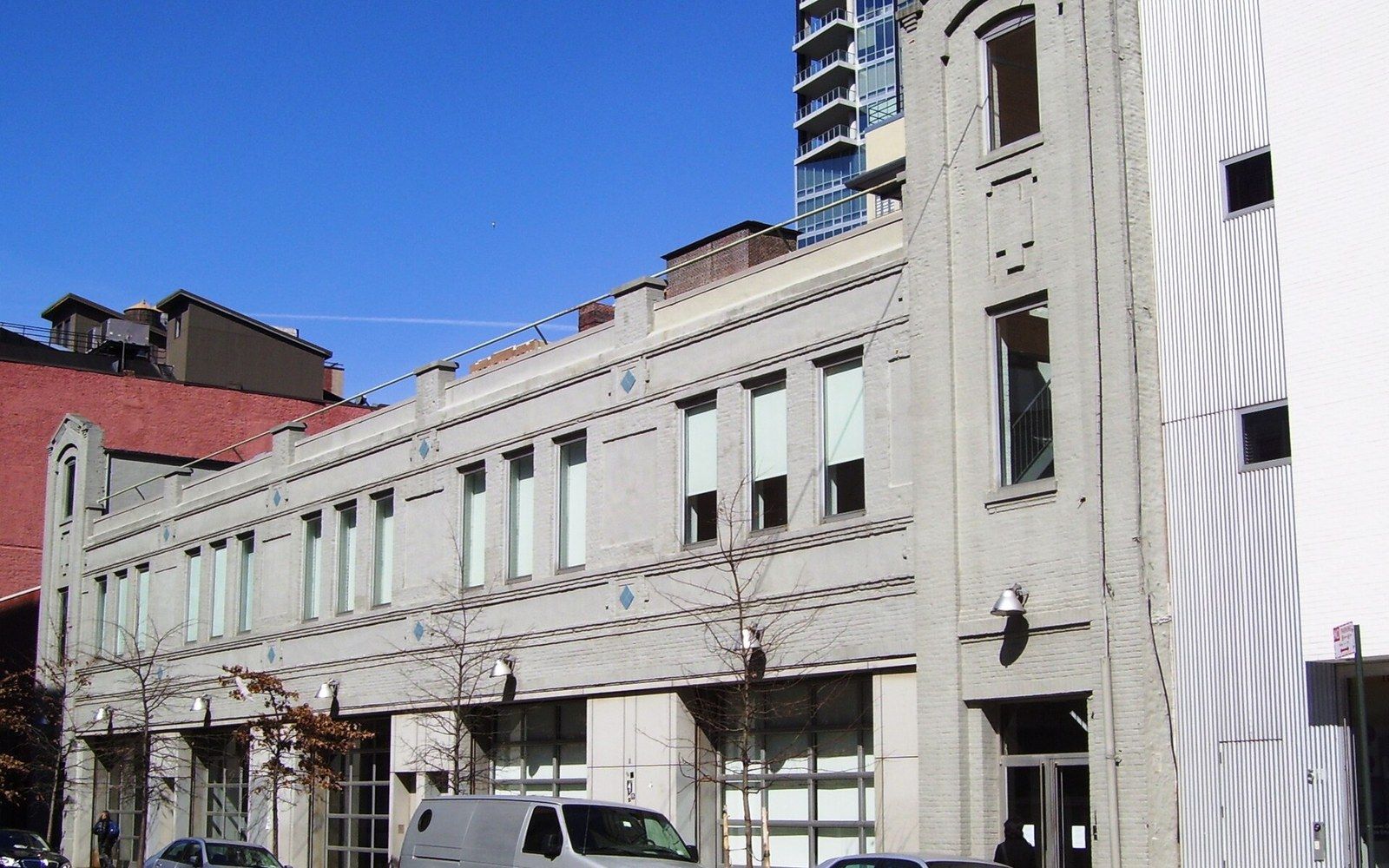 Low-rise brick gallery building with rows of tall windows on a city street