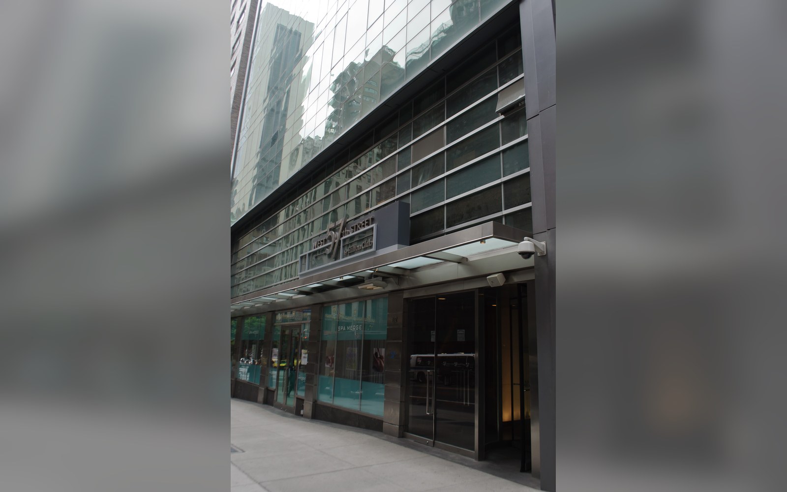 Glass and metal facade entrance of an office building with a canopy over the doorway